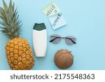 Ripe pineapple, coconut, sunglasses and bottle of cream on a blue background. Hello summer concept