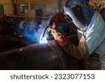 Small photo of Welder is welding added joint a pipe carbon for steel structure work with process Flux Cored Arc Welding(FCAW) and dressed properly with personal protective equipment(PPE) for safety.