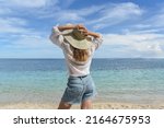 a woman is resting on the beach.... | Shutterstock . vector #2164675953