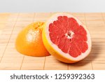 Small photo of the grapefruit, cut in two, lies on a wooden bamboo Board