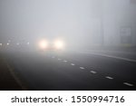 Motion of cars with headlights on during heavy fog