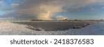 Small photo of Brake, Germany - January 18, 2024: scenic snowy winter panorama of the biotope Kleiputte and the factory Rehau in background - a dynamic cloud can be seen in the sky