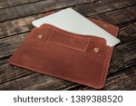 Beige leather bag on the wooden dark table brown natural color case for laptop or paper