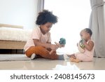 Small photo of Happy African siblings in family, brother boy with black curly hair playing with cute toddle baby infant sister girl while sitting on floor in bedroom, kids playing toy, child spending time together.