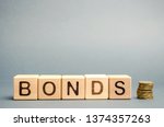 Wooden blocks with the word Bonds and coins. A bond is a security that indicates that the investor has provided a loan to the issuer. Equivalent loan. Unsecured and secured bonds