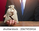 Small photo of Man gives a Indian rupee money bag. Loan issuance. Financial support, leasing. Investments, financing Lobbying. Funding. Accounting, tax payment. Earnings and profits.