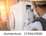 Small photo of Air Conditioning Technician and A part of preparing to install new air conditioner. Technician vacuum pump evacuates and checking new air conditioner