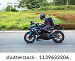 Small photo of A biker riding a Kawasaki Eva motorcycle on Hiram's Highway in Sai Kung ,Hong Kong and with blur background ,Photo taken on 22 July 2018