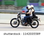 Small photo of A biker riding a Honda CB400 motorcycle with a passenger on the Hiram's Highway in Sai Kung Hong Kong and with blur movement, Photo taken on 25 July 2018
