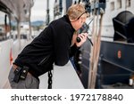 Superyacht crew member coordinating a vessel haul out on travel lift with handheld radio