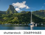 Small photo of Paradise location in tropical island, Cook's Bay in Moorea, French Polynesia, on a sunny day with blue skies, beautiful mountains in the background with superyachts at anchor.