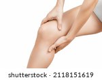Small photo of Closeup young woman feeling knee pain and she massage her knee. Healthcare and medical concept. Close-up painful knee. Close up of female hands holding knee.