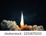 Small photo of Space rocket shuttle with blast and puff of smoke lift up to the dark starry space sky. Spaceship launch. Start up, creative idea. Take off
