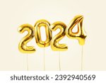 Small photo of Happy new year 2024 metallic gold foil balloons flying on a beige background. Golden helium balloons number 2024 New Year.