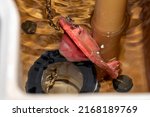 Small photo of A rubber flapper valve during flushing in a toilet tank illustrating severe chlorine damage.