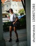 Small photo of Portrait of an unselfconscious, attractive and young Chinese Asian model girl smiling and goofing around as she poses for her photo on a street in Asia. She is tall, slim, cute and fashionable.