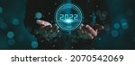 Small photo of Businessman hand holding 2022 number,happy new year concept digital trends,industry and business trend of world full modernity advanced technology,artificial intelligence or AI,banner header panoramic