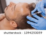 Close up of a mature man receiving hairloss treatment injections in scalp by professional trichologist. Dermatologist doing scalp injections for mature male client with alopecia problem