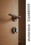 Small photo of Modern metallic door handle on medium density fiberboard bedroom door, selective focus
