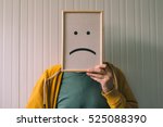 Put a sad pessimistic face on, sadness and depressive emotions concept, man holding picture frame with smiley emoticon printed.