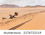 Small photo of Old rusty unused railroad switch at Wadi Rum train station, tracks covered with sand near, desert and mountains in background
