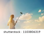 girl doing selfie on blue sky background. Woman holding a phone with Instagram IGTV.