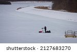 Small photo of An Ice-Fisherman getting ready to drill a hole in the thick ice with a motorized augur. Ringneck Marsh. Iroquois National Wildlife Refuge. Basom, New York, USA, February 22nd, 2022