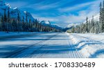 Small photo of Icy road with fir full of snow all along the road, Canada