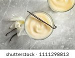 Vanilla pudding, sticks and flower on light background