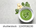 Flat lay composition with fresh vegetable detox soup made of spinach and space for text on table