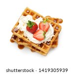 Small photo of Yummy waffles with whipped cream, strawberries and caramel syrup on white background, top view