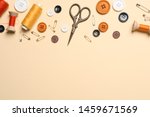 Flat lay composition with scissors and other sewing accessories on light yellow background, space for text