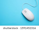 Wired computer mouse on light blue background, top view. Space for text