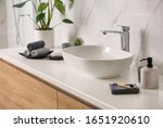 Stylish vessel sink on light countertop in modern bathroom