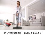Young Woman Using Vacuum...