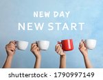 Inspirational text New Day New Start over people holding cups on light blue background