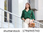 Beautiful young woman with stylish leather bag outdoors on summer day