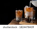 Making tasty milk bubble tea on wooden table. Space for text