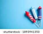 Firework rockets on light blue background, flat lay. Space for text
