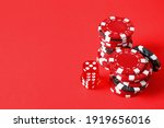 Poker chips and dices on red background, space for text