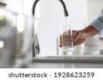 Man pouring water into glass in ...
