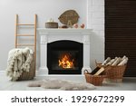 Wicker baskets with firewood and white fireplace in cozy living room