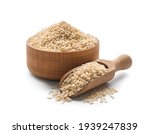 Wooden bowl and scoop with sesame seeds on white background