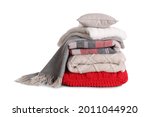Stack of pillows and folded warm plaids on white background
