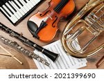 Set of different musical instruments on wooden background, flat lay