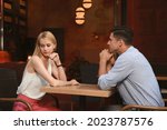 Bored couple having unsuccessful date in cafe