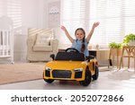 Adorable Child Driving Toy Car...