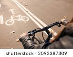 Woman riding bicycle on lane in city, closeup