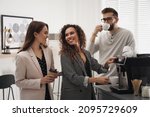 Small photo of African American woman talking with colleagues while using modern coffee machine in office