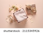 Open gift box, confetti and roses on pink background, flat lay.